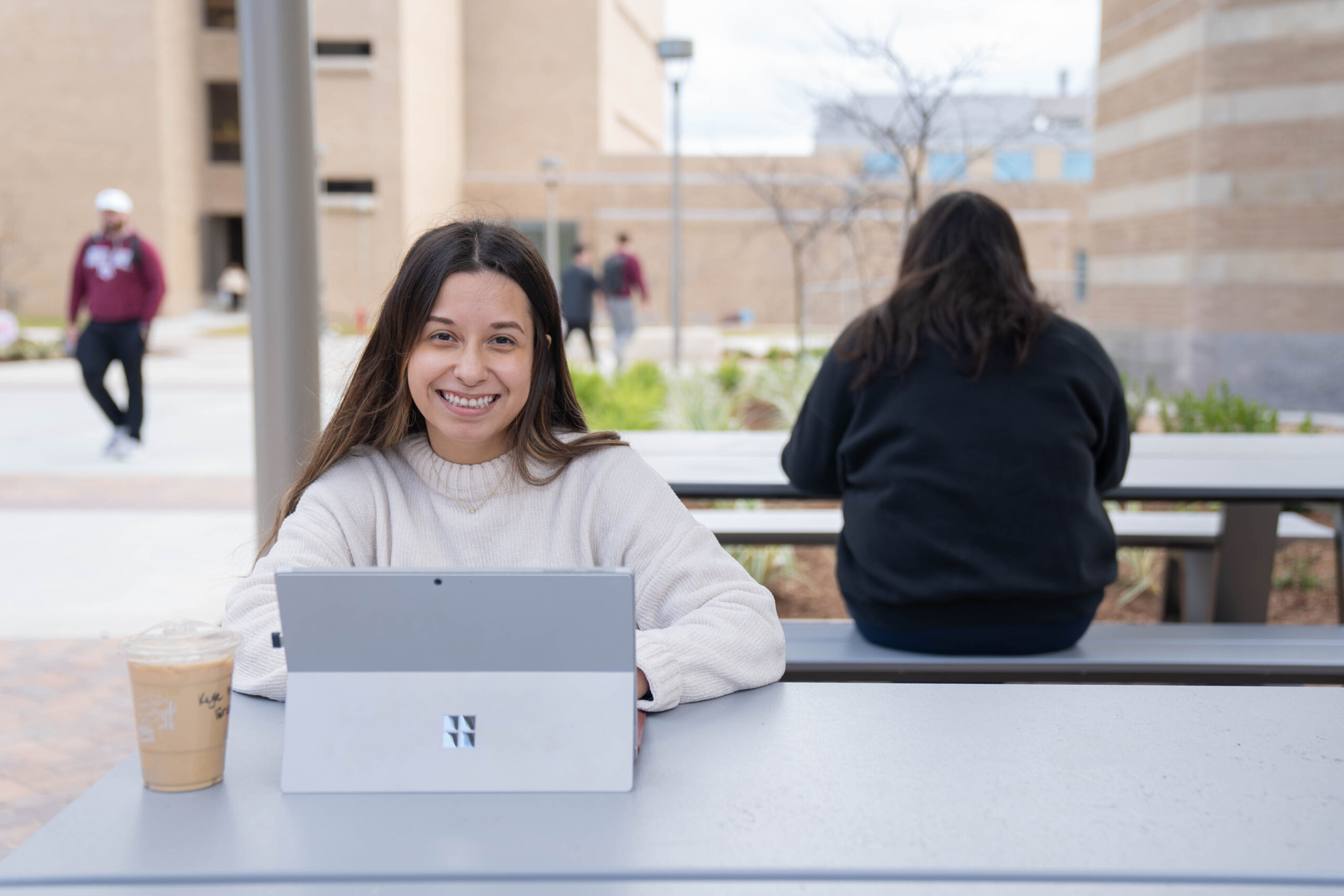 A student working on a laptop outdoors at the ConocoPhillips Collaboration Plaza