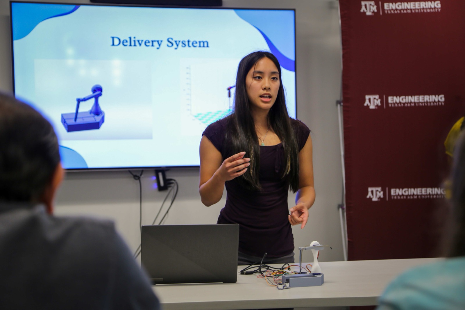 Jevine Kong presenting FlowSmart’s prototype to an audience at Aggies Invent